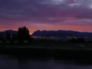 a sunset with a city and mountains in the background at Atardecer en la Estepa in Dina Huapi