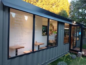 a building with windows with a bench in it at Atardecer en la Estepa in Dina Huapi
