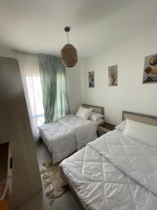 a bedroom with two beds and a pendant light at Mountain view north coast in Banī Ghālib
