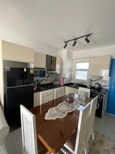 a kitchen with a wooden table with chairs and a dining room at Mountain view north coast in Banī Ghālib