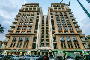 un grande edificio con auto parcheggiate di fronte di Bayil apartment by Baku Housing a Baku