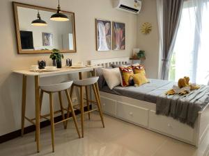 Un pequeño dormitorio con una cama y una mesa. en Moonlight Chic Living, en Lapu Lapu City 3 fotos más