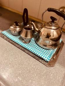 two tea pots and pans on a tray on a stove at Temporario del Sur in Santiago del Estero