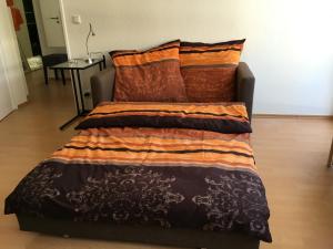 ein Bett mit einer Decke und Kissen darauf in der Unterkunft Geschmackvolle Wohnung in Offenbach in Offenbach