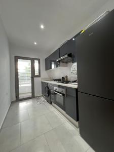 een keuken met een zwarte koelkast en een fornuis bij Lux Rentals 2 chambres - CaboNegro in Cabo Negro