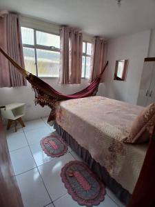 a bed in a room with a hammock in it at Apartamento 2 quartos próximo ao Parque do Povo no centro de Campina Grande in Campina Grande +6 photos