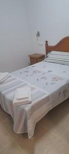 a bed with two towels sitting on top of it at Apartamento calle Senado in Garrucha