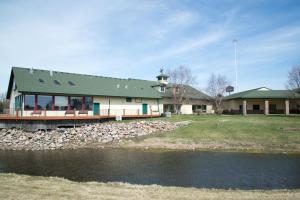 un grande edificio con una chiesa accanto a un corpo d'acqua di HomeTown Inn and Suites Belle Plaine a Belle Plaine