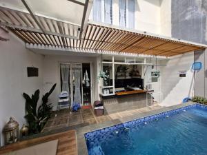 a swimming pool in a house with a wooden awning at Ciara Villa with private pool in Batu