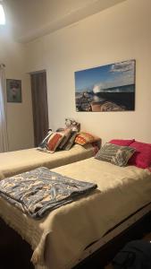 two beds in a room with a painting on the wall at Casa en corazón zona de bodegas in Perdriel
