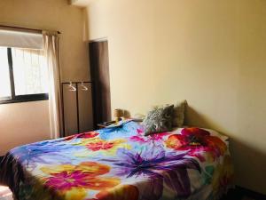 a bedroom with a bed with a colorful blanket at Casa en corazón zona de bodegas in Perdriel