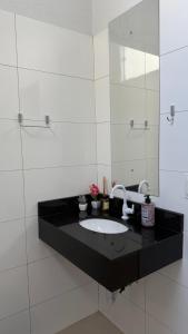 a bathroom with a sink and a mirror at Nalevaiko - Kitnet Moderna e Funcional in Sinop