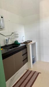 a small kitchen with a sink and a counter at Nalevaiko - Kitnet Moderna e Funcional in Sinop