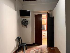 a hallway with a chair and a door with a fan at Hotel Casa don Angel in Las Victorias