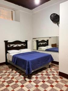 a bedroom with two beds and a checkered floor at Hotel Casa don Angel in Las Victorias
