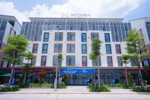 ein weißes Gebäude mit Bäumen davor in der Unterkunft Mey Mansion Hotel Phu Quoc in Phu Quoc