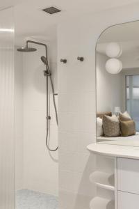 un baño con ducha y lavabo en The Isla on Hastings, en Noosa Heads