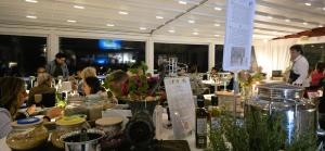 een groep mensen die aan een tafel zitten met bloemen in potten bij Relais Villa Olivi in Costermano +37 foto's