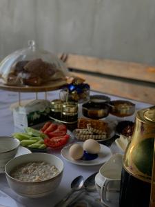 a table topped with bowls and plates of food at Ainazik guest house in Toktogul
