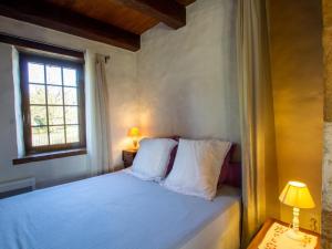 a bedroom with a bed with white pillows and a window at Charmante Maison de Campagne avec Jardin Clôturé, Cheminée et Wi-Fi Proche de la Dordogne - FR-1-616-150 in Saint-Capraise-de-Lalinde