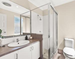 a bathroom with a sink and a glass shower at 78 Modern Comforts Quiet Charm 3BR 2BA Parking in Perth +10 photos