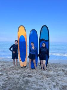 MantaakにあるBudalsurfingの海岸に立ちサーフボードを持つ人々