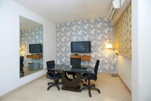 a dining room with a table and chairs and a television at Hotel O Gem 92 in New Delhi +46 photos