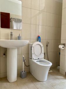 a bathroom with a white toilet and a sink at Your Pristine Home Away 2BR 2BA Bunga Munyonyo in Kampala