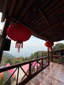 two red lanterns on a balcony with a view at Thiên Cẩm Sơn Camping-Homestay Núi Cấm in Phum Cần Chai Krom