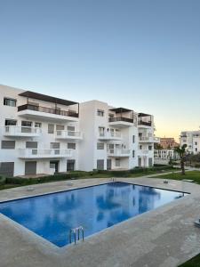 an apartment with a swimming pool in front of a building at Appartement Moderne à CABO Huerto Del Rio in Cabo Negro
