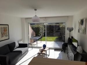 a living room with a couch and a table at Charmante maison de plage à Merlimont - 6 personnes, terrasse et WIFI - FR-1-672-39 in Merlimont