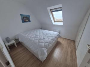 a white bedroom with a bed and a window at Charmante maison de plage à Merlimont - 6 personnes, terrasse et WIFI - FR-1-672-39 in Merlimont