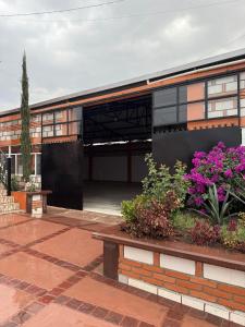 a building with a courtyard with purple flowers at Hotel La C in San José Iturbide