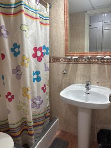 a bathroom with a sink and a shower curtain with flowers at Hotel Don Jose in Puertollano +51 photos