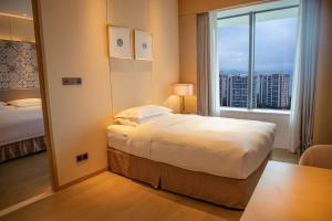 Voodi või voodid majutusasutuse Wyndham Grand Plaza Royale Yuzhou Xiamen Wuyuan Bay toas