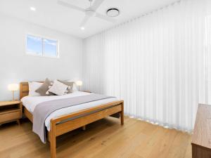 Baja on Cylinders - Beachfront Bliss في كينغسكليف: غرفة نوم بيضاء مع سرير ونافذة