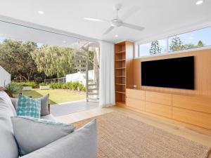 Baja on Cylinders - Beachfront Bliss في كينغسكليف: غرفة معيشة مع تلفزيون وأريكة