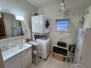 a bathroom with a sink and a washing machine at Nomad Stay Chitose in Chitose +47 photos