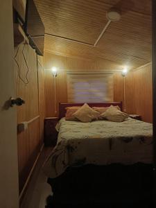 a bedroom with a bed with two pillows on it at Cabaña Alba in Puerto Montt