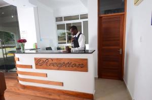 a man is standing at a reception desk at Greenpark Sundowner in Athi River