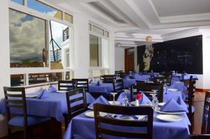 un comedor con mesas y sillas azules en Greenpark Sundowner en Athi River