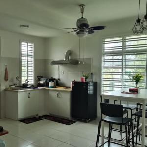 a kitchen with a refrigerator and a table with chairs at Mstaycation in Kampong Ayer Panas