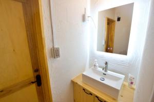 a bathroom with a sink and a mirror at 沖縄古民家 Villa JYANA in Nakijin