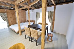 a room with a bed and a table and chairs at 沖縄古民家 Villa JYANA in Nakijin