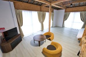 a living room with a television and a table and chairs at 沖縄古民家 Villa JYANA in Nakijin +64 photos