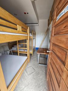 a room with two bunk beds and a wooden door at San Juan Hostel in Sampong +29 photos