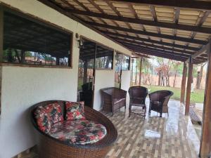 a porch with a couch and chairs and a table at Sítio Aconchego Contagem in Contagem