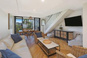 Una sala de estar con un sofá y un televisor. en TARA7- On Trend At Taranaki, en Mooloolaba
