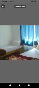 2 letti in una camera con tende blu di Monika Guest House a Bodh Gaya