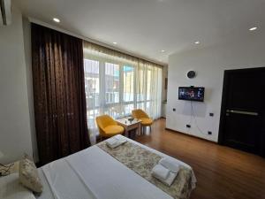a hotel room with a large bed and a television at Green Garden Apartments in Yerevan